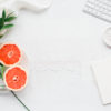 grapefruit on a desk with keyboard and book